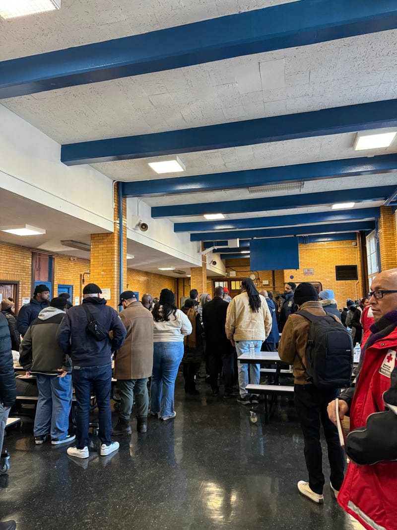 Residents displaced by the fire congregate at a temporary shelter at P.S. 76.