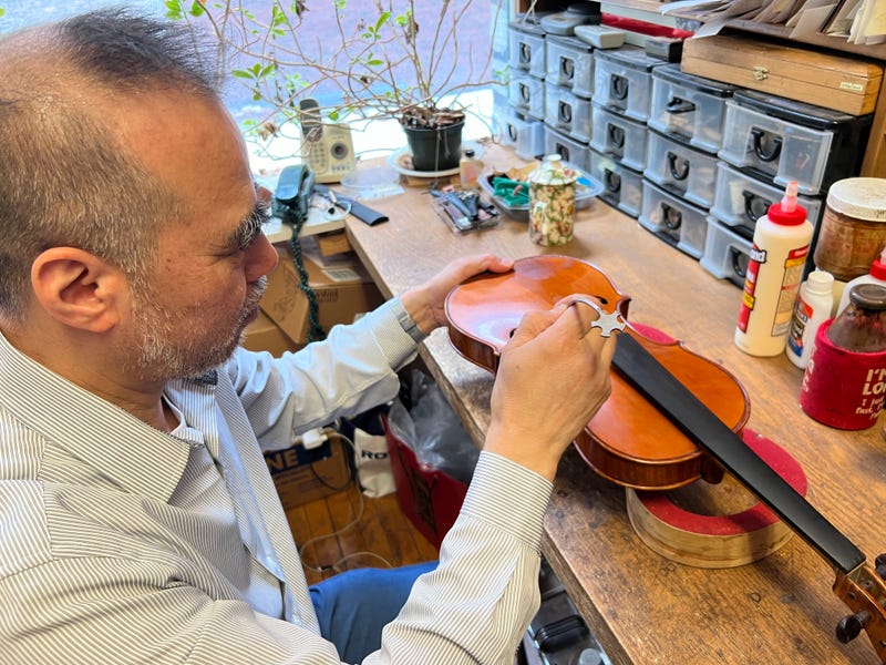 Chunyee Lu, founder of Chicago's Guadagnini Violin Shop, works on a violin.