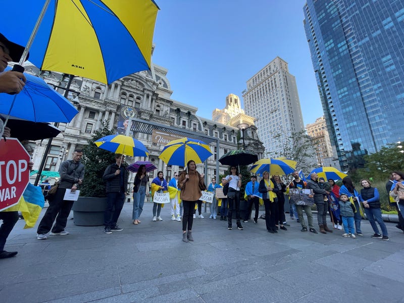 Protesters stand outside City Hall on Oct. 10, 2022, with blue and yellow umbrellas — the colors of the Ukrainian flag — to represent a symbolic shield for Ukraine as it faces airstrikes from Russia.