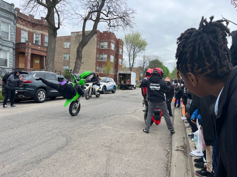 Students at Genevieve Melody STEM Elementary School, located in West Garfield Park, crane to get a better view of a dirt bike showcase from the Baltimore-based B-360.