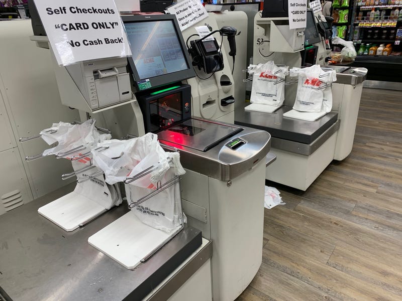 The checkout at an Acme location which uses single-use plastic bags.