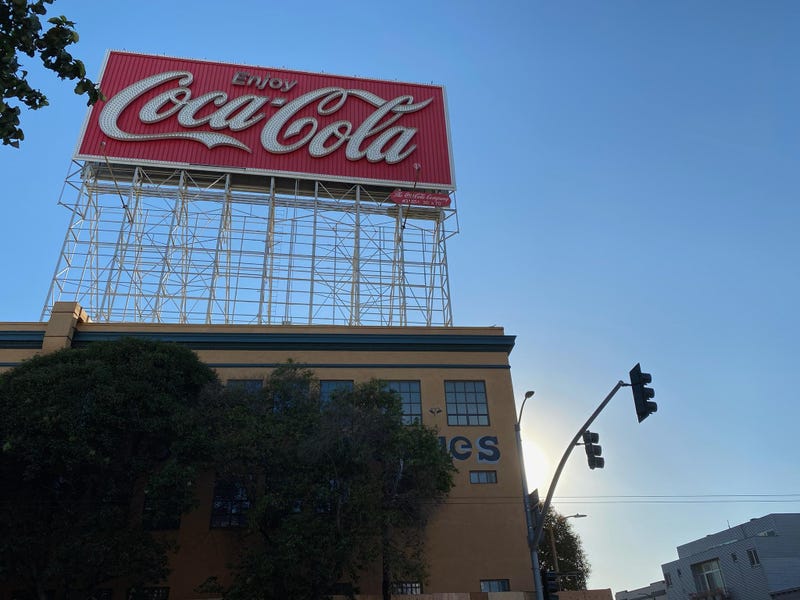 The sun sets on San Francisco's famous "Enjoy Coca-Cola" sign.