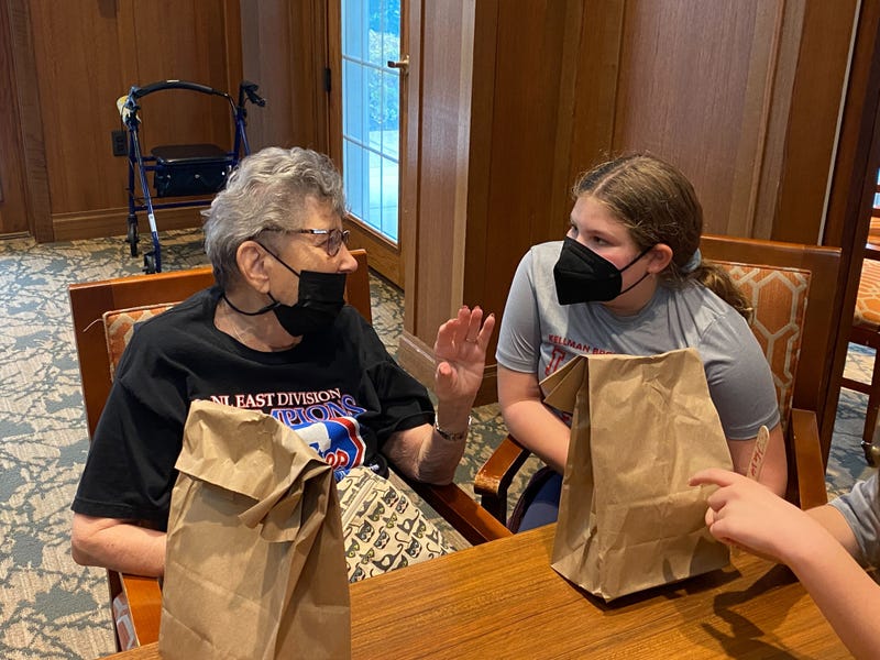 Lois Goldberg, 86, and fifth-grader Natalie from Kellman Brown Academy talk the big topic of discussion in the Delaware Valley, the Phillies.
