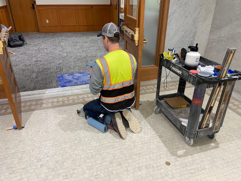 A worker freshens up some of the new finishes in the mayor's office area in City Hall's third floor.