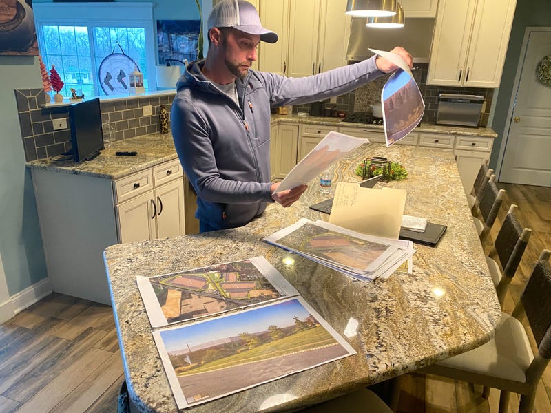 Adam Pennypacker looks at printed renderings of construction plans for a massive warehouse complex