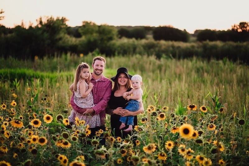 Vicari family stands in a field of sunflowers