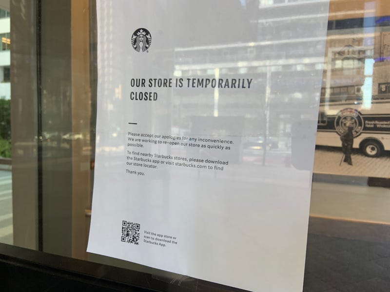 A sign on a door saying, "Our store is temporarily closed."