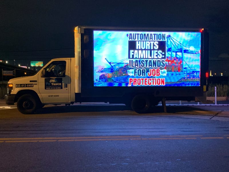 A truck with a screen on the side displayed various union messages, like, “Machines don’t feed families.”