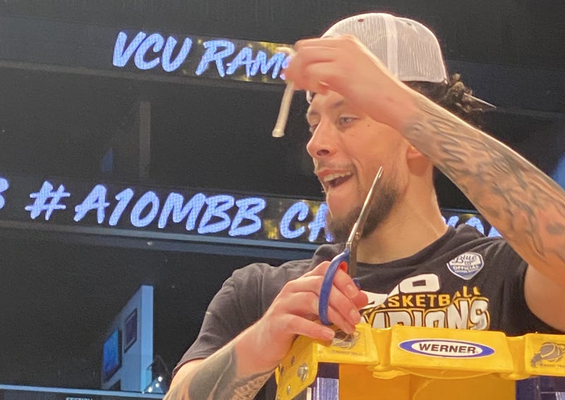 Brandon Johns Jr. cuts a piece of the net after VCU won the 2023 A-10 Tournament in Brooklyn at the Barclays Center.