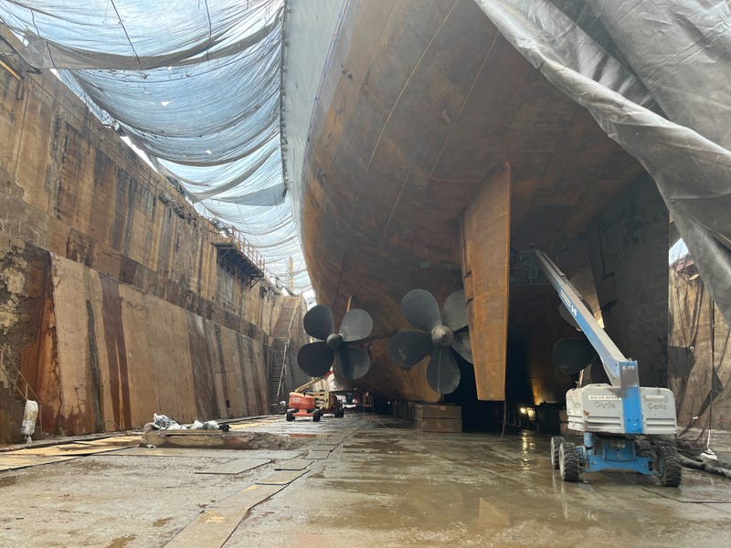 Work crews inspect and clean the underside of the Battleship New Jersey to prepare the vessel for a new paint job before it makes the short trip up and across the Delaware River to Camden, N.J.