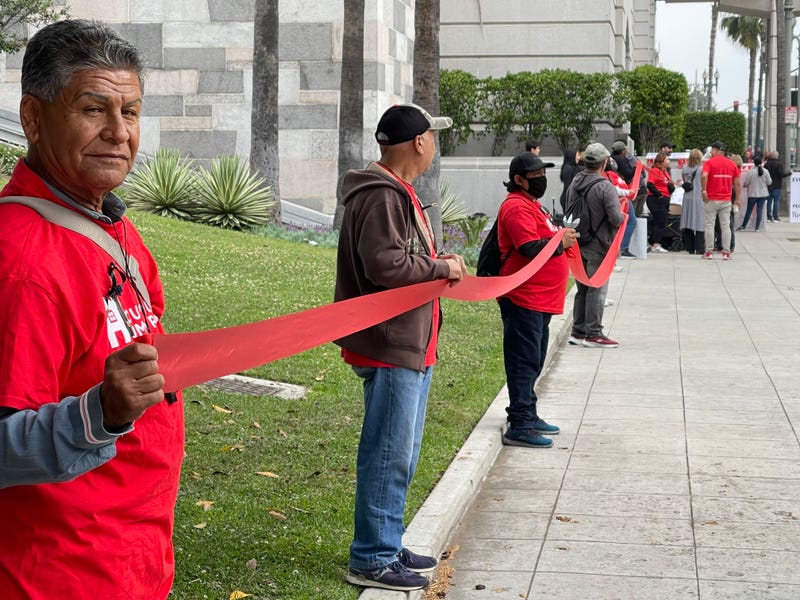 people holding red ribbon