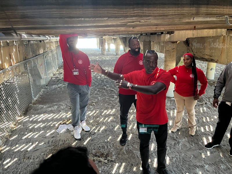 Jarrod Barnes (front) explains where officials closed access to a popular encampment location under the Garden Pier in Atlantic City.