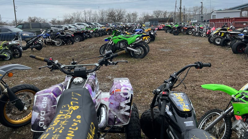 Dirt bikes and all terrain vehicles lined up at a police impound lot