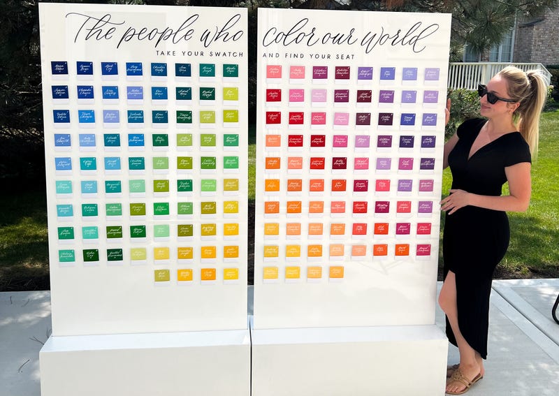 Amanda Tiberi, founder of XO Art and Design, stands next to a seating chart she designed and wrote out for a wedding.