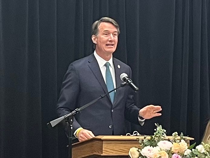 Governor Youngkin stands at a lectern, addressing a crowd