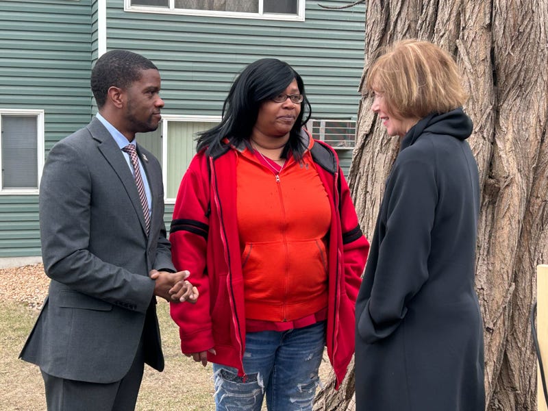 St. Paul Mayor Melvin Carter (left) and U.S. Senator Tina Smith (right) speak with a resident at Vista Village Apartments.