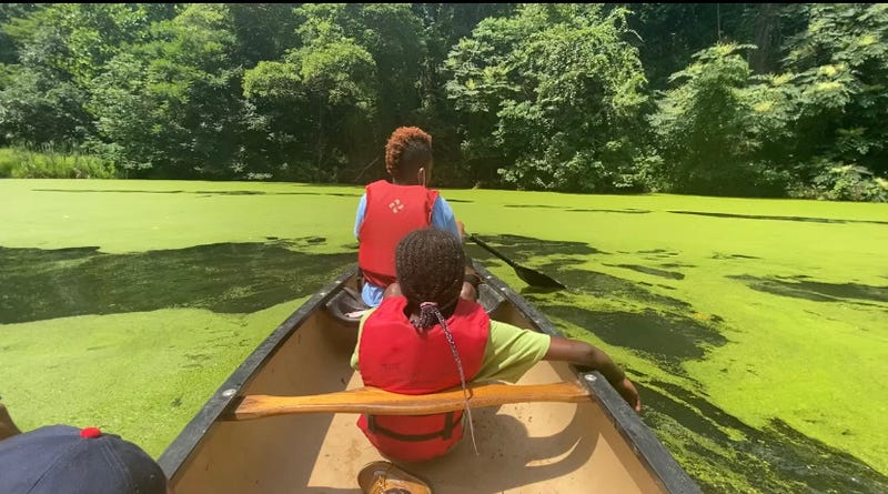 Kids row a boat at Camp Excellence