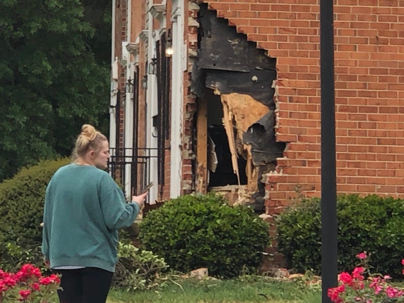 Woman looks at damaged apartment along Bremner Boulevard.