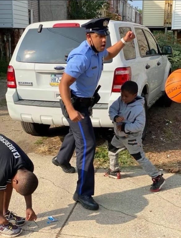 Temple University police officer Christopher Fitzgerald playing with children. He was shot and killed Saturday night in the line of duty.