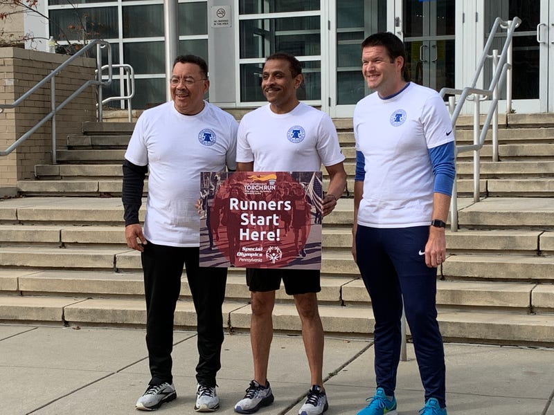 Supt. Tony Watlington (center) prepares to take the torch with School Safety Chief Kevin Bethel (left) and Dr. James Lynch, executive director of athletics. 