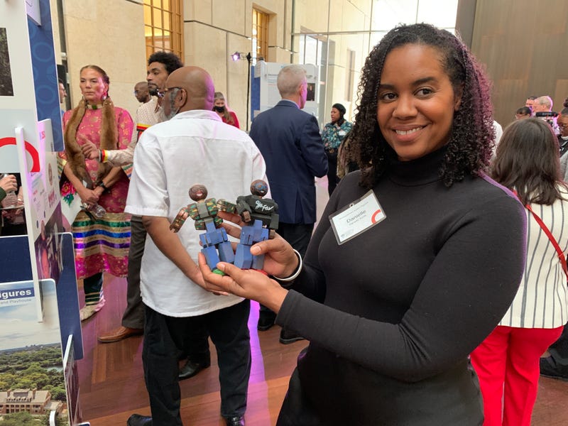 Danielle Smith holds action figures at the Philadelphia250 announcement on Dec. 14 at the Barnes Foundation.