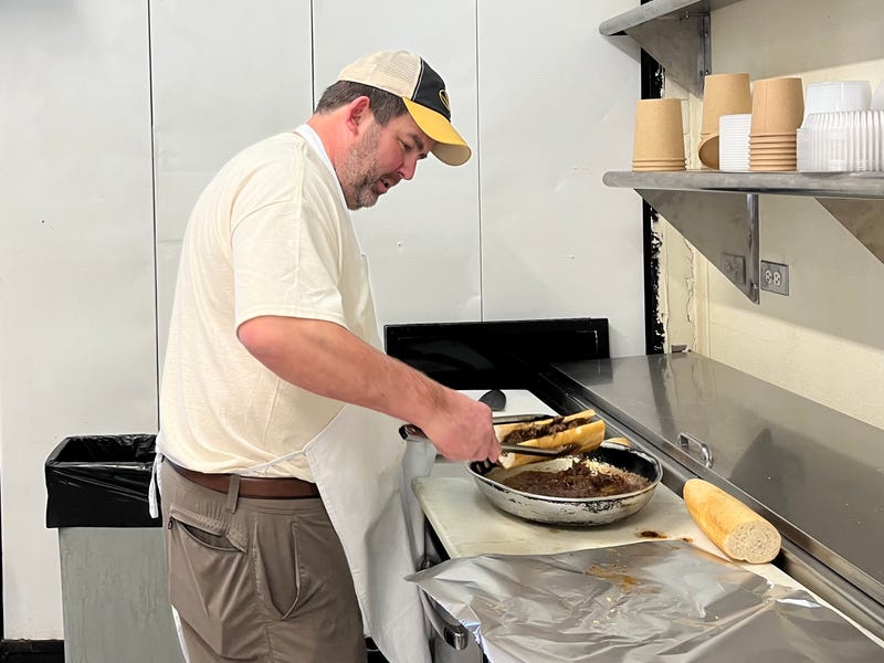 Craig Rutherford dips the pot roast sandwich in gravy