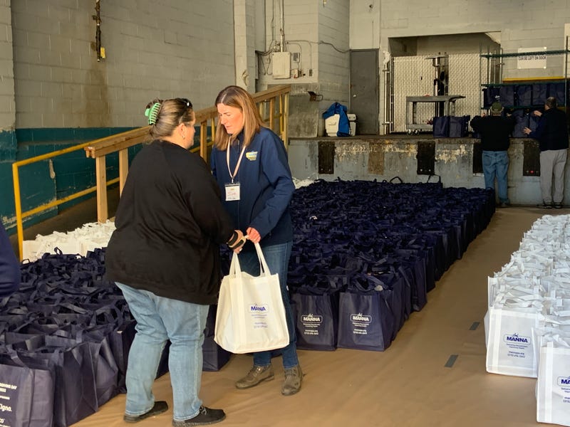 A MANNA volunteer picks up bags to carry away in her car.