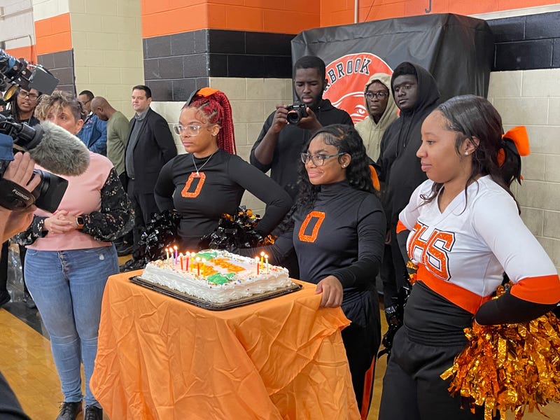 Overbrook High students prepare to bring a cake to honor former teacher Joyce Abbott at a ceremony honoring Abbott's work at the school.