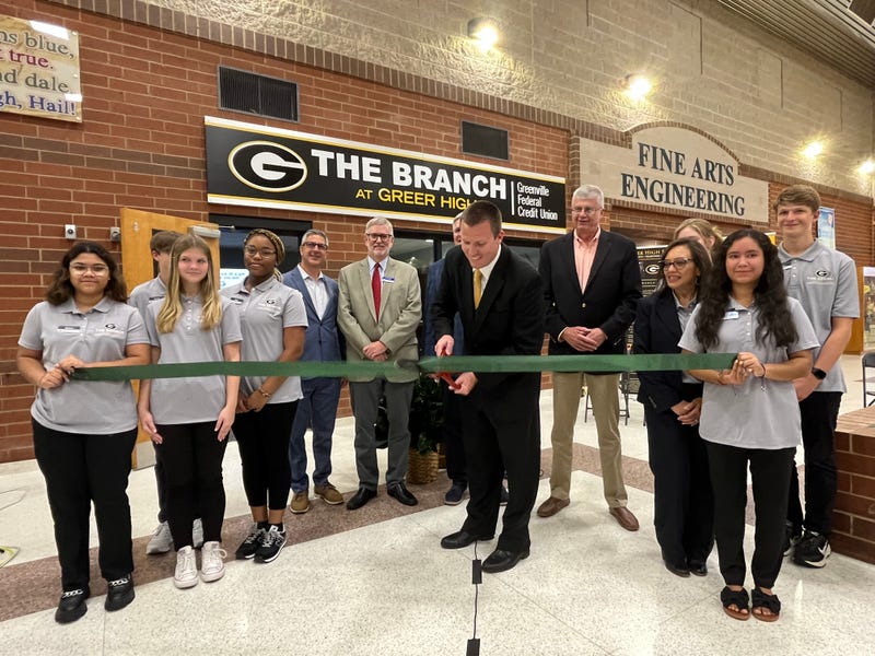 Greer High Principal Justin Ludley cuts the ribbon in front of the new credit union branch