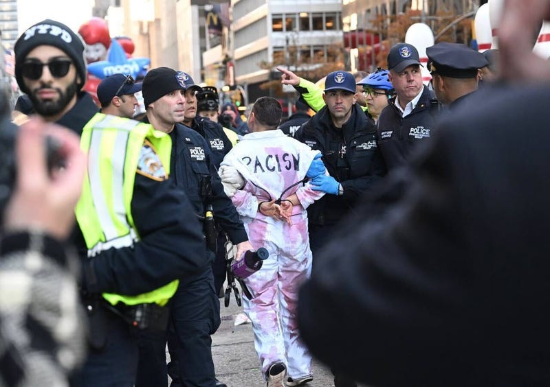 New York Police Department (NYPD) members intervene and take two pro-Palestinian protesters into custody, who entered the parade, during the traditional Thanksgiving Day parade in New York, United States on November 23, 2023. 