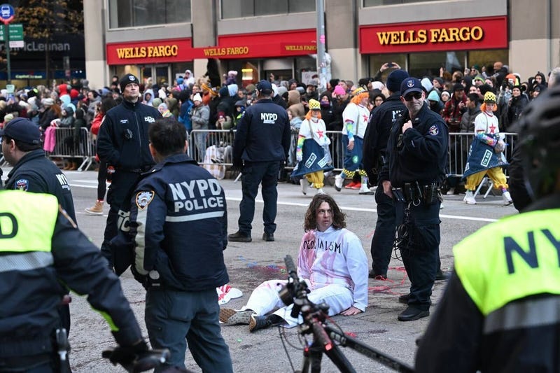 New York Police Department (NYPD) members intervene and take two pro-Palestinian protesters into custody, who entered the parade, during the traditional Thanksgiving Day parade in New York, United States on November 23, 2023. 