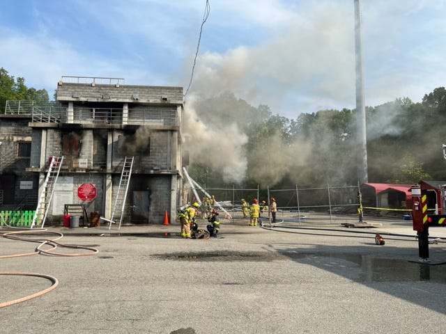 A building surrounded by firefighters