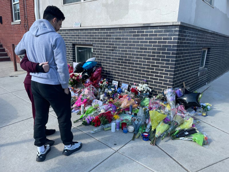 Family members gather at the corner of Montgomery Avenue and Bouvier Street where a makeshift memorial has been created for Temple University police officer Christopher Fitzgerald, who was shot and killed Saturday night.