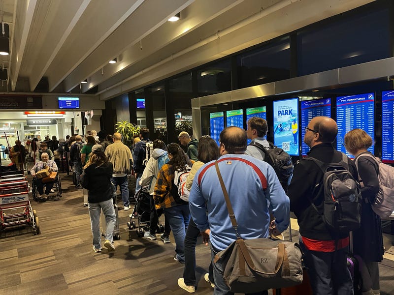Airline travelers wait in long lines due in part to the partial DHS shutdown