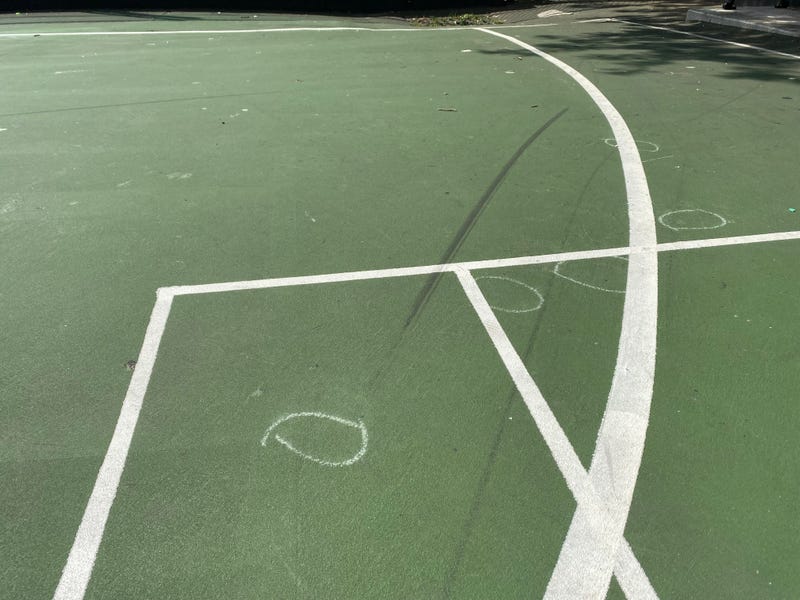 Chalk outlines, showing where bullet casings were found, remained on the playground athletic courts.