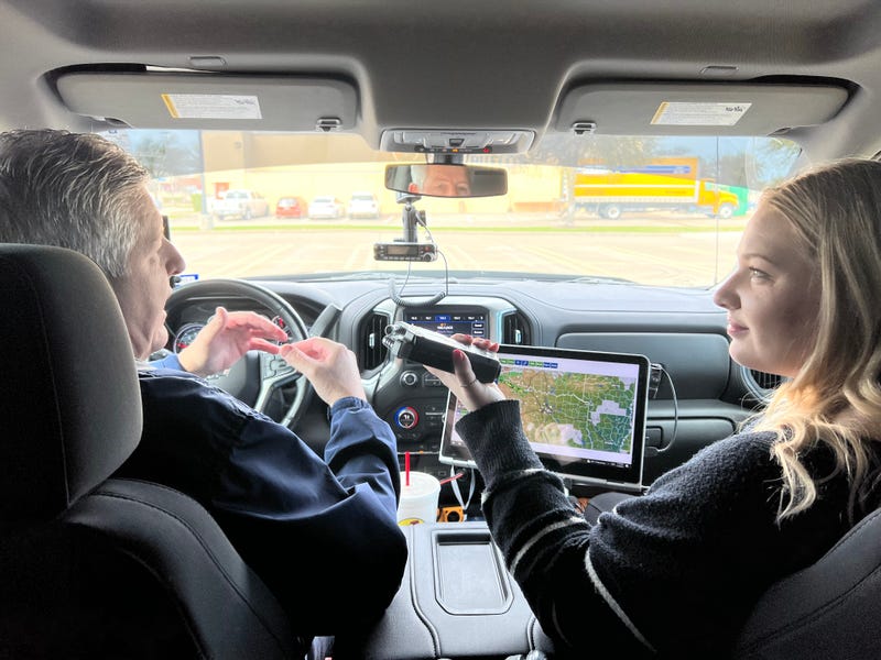 Storm chaser Joe Bajza, right, shows Baylee Friday, left, the technology he uses when he's out tracking severe weather.