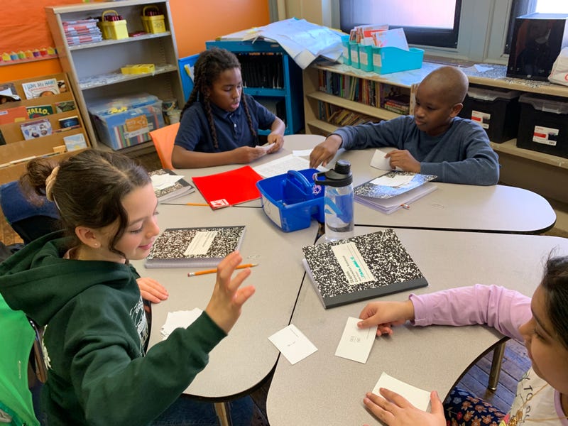 Zeviah Narva-Yalowitz (bottom left) and her classmates play the card game "War," but with fractions, in math class at Henry C. Lea Elementary.