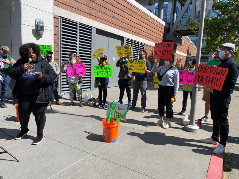 About a dozen members of Oakland community groups rallied outside the Athletics’ Jack London Square offices on Wednesday, calling on the team to include more community benefits in their Howard Terminal project proposal. 