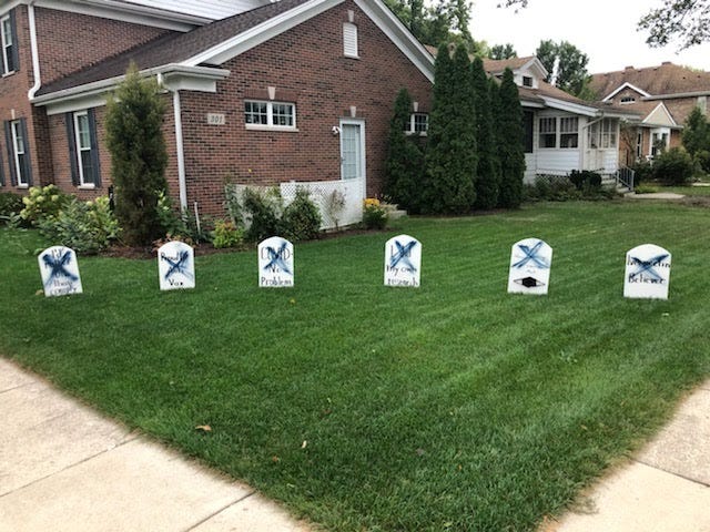 Pro-vaccine Halloween display featuring tombstones defaced in Park Ridge