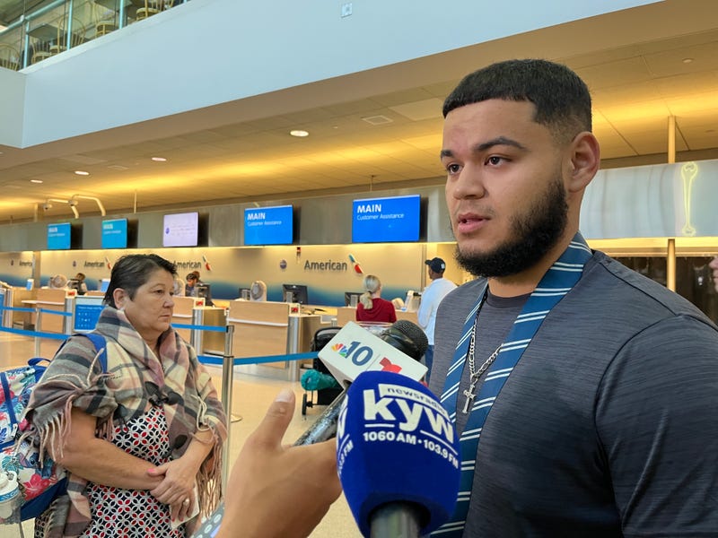 Felix (right) is traveling to Puerto Rico with his grandmother (background) from Philadelphia International Airport on Sept. 20, 2022.