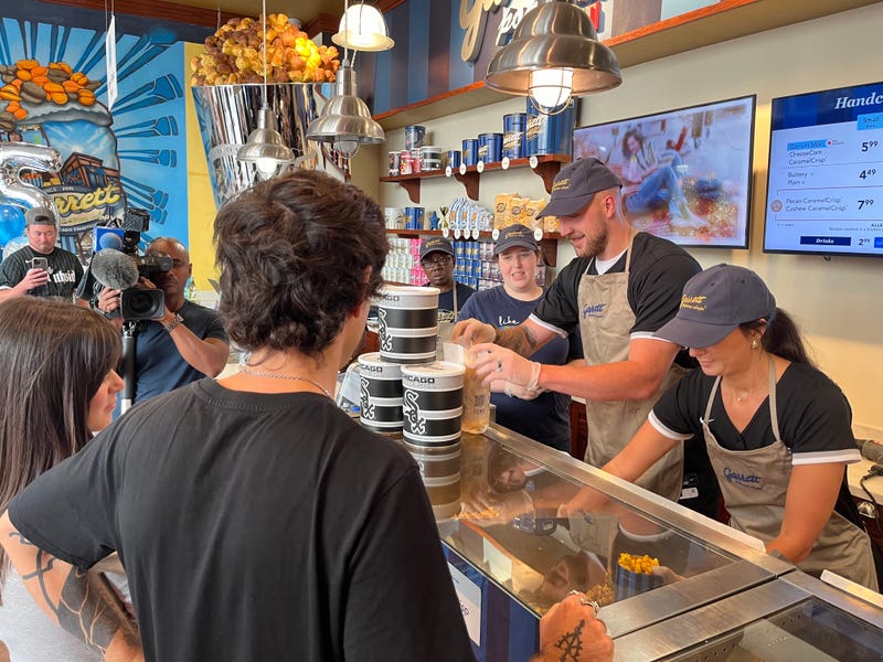 Chicago White Sox pitcher Garrett Crochet and his wife Rachel serve patrons at Garrett's Popcorn Shop on Michigan Avenue in Chicago on Sept. 10, 2024. The pair spent one hour behind the counter as part of the popcorn company's "Scoop for a Cause" campaign, from which a portion of the sales will benefit Chicago White Sox Charities.