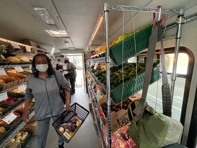 People shopping the Fresh Moves Mobile Market bus.