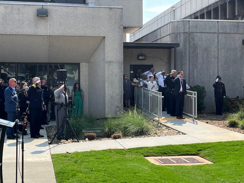 Law enforcement officials saluting during the ceremonial raising of the flag to half mast at the Greenville County Sheriff's Office memorial ceremony