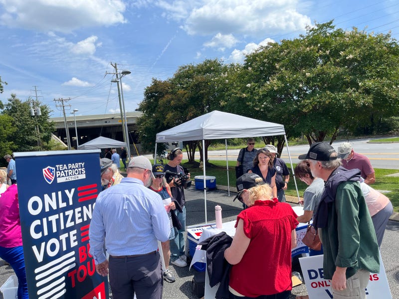 A crowd lining up to sign a petition at the Only Citizens Vote bus tour