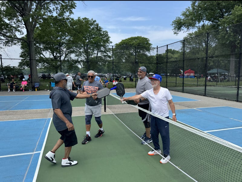 group of pickleballers shake hands at net
