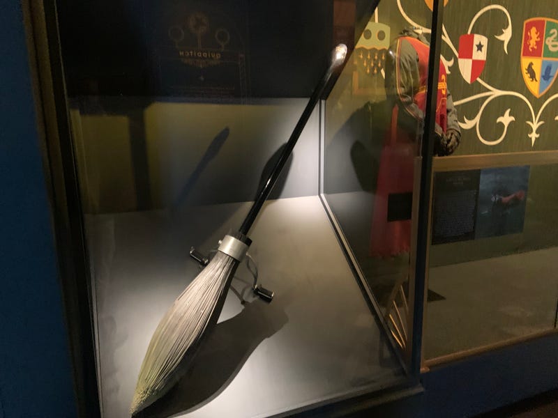 A broomstick and Quidditch player's uniform are on display at the Franklin Institute.