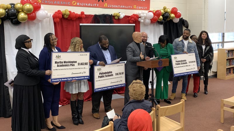 State Sen. Vincent Hughes and state Rep. Jordan Harris present Philly public schools with state grant checks for building improvements.
