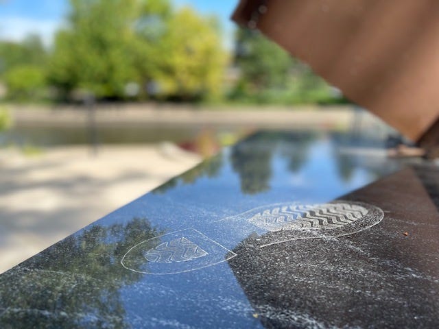 Shanower's boot print, a perennial garden, a bench, and a wall of faces make up the memorial at 400 South Eagle Street along the Riverwalk.