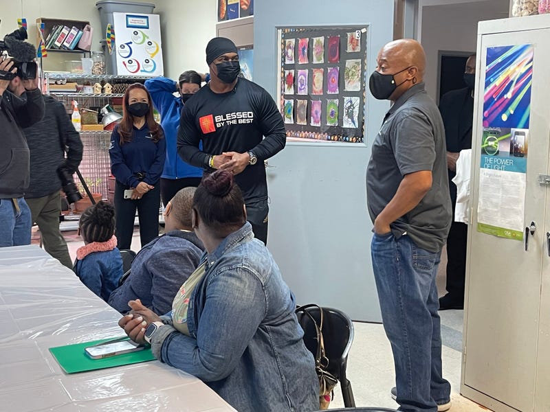 NFL Hall of Famer Brian Dawkins (center, standing) meets with families at the Caring People's Alliance Boys and Girls Club in North Philadelphia.