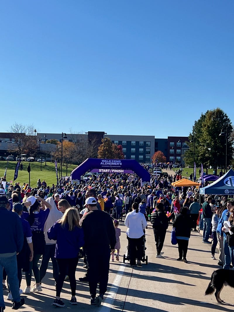 Walkers go through a starting gate at the 2024 St. Louis Walk to End Alzheimer's in Chesterfield Park